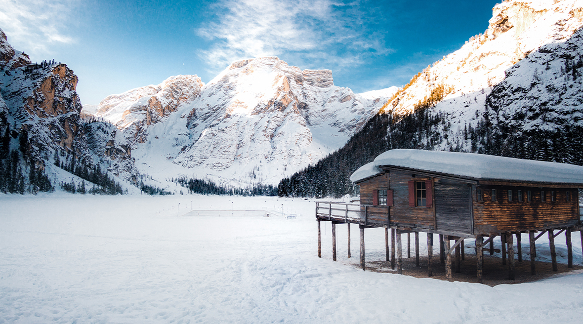 Frozen Brais Lake and cabin, overlooking the Dolomite mountains